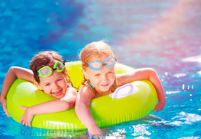 Niñas jugando en la piscina con un flotador